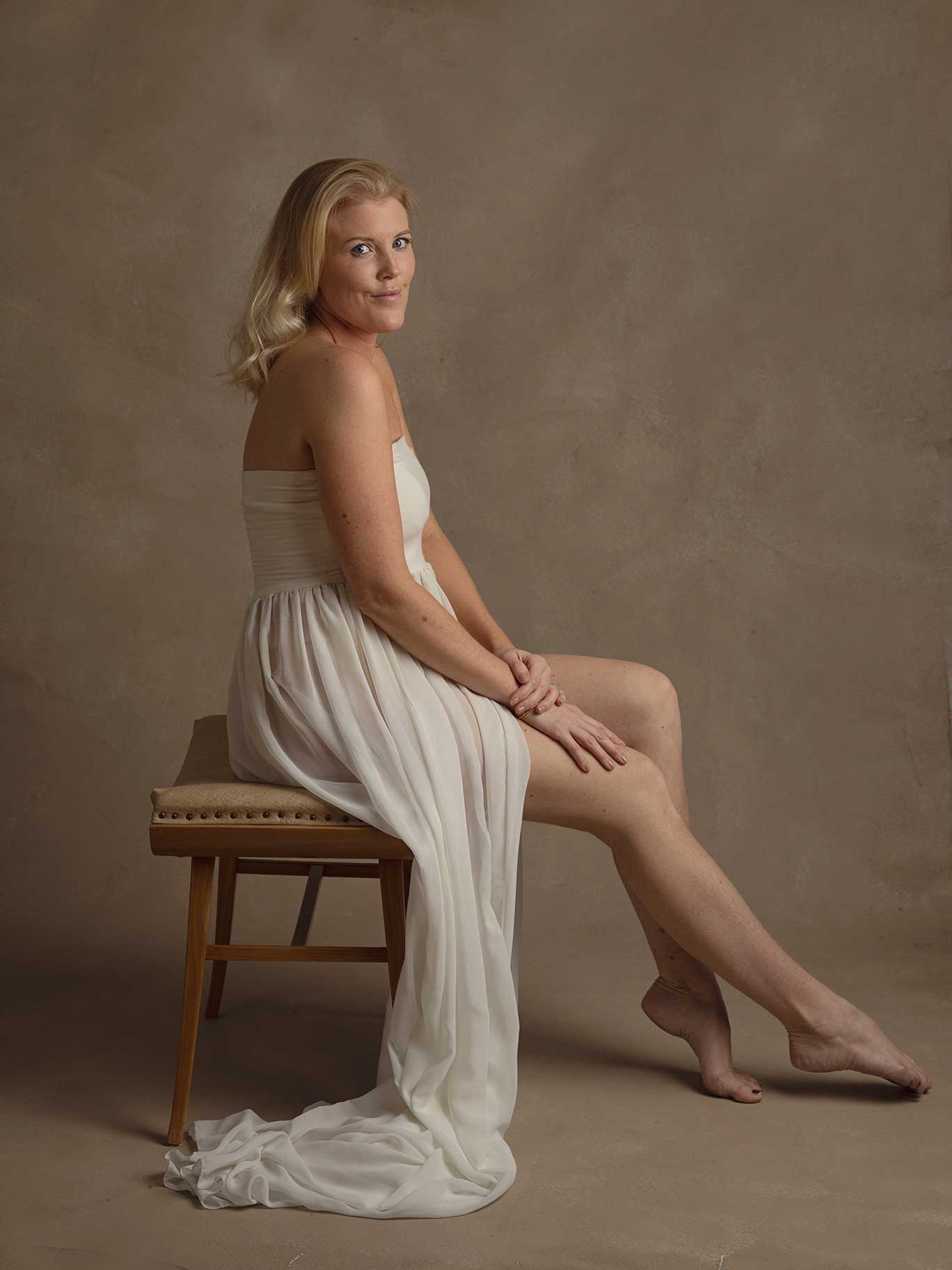 En tjej i vit, skir klänning blir fotograferad.