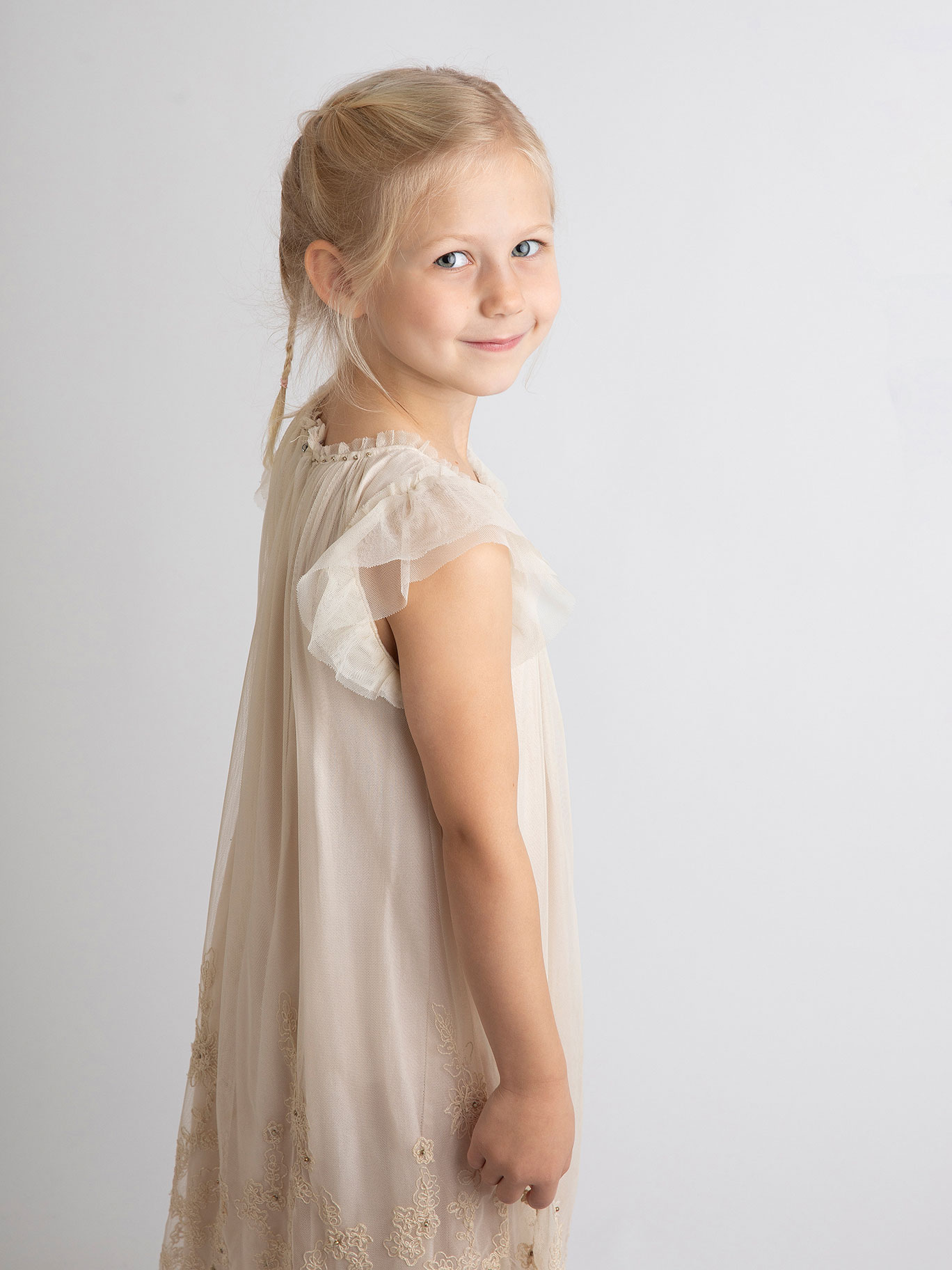 Flicka i skolåldern ler mot kameran.