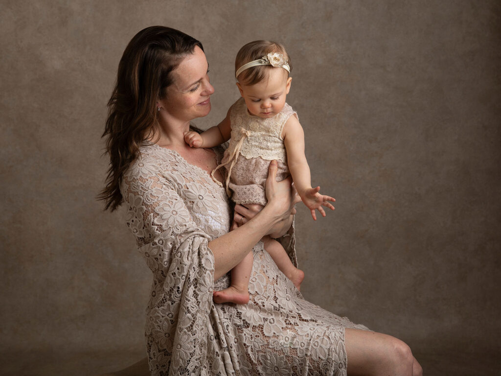 Mamma med sn baby i famnen under en fotografering.