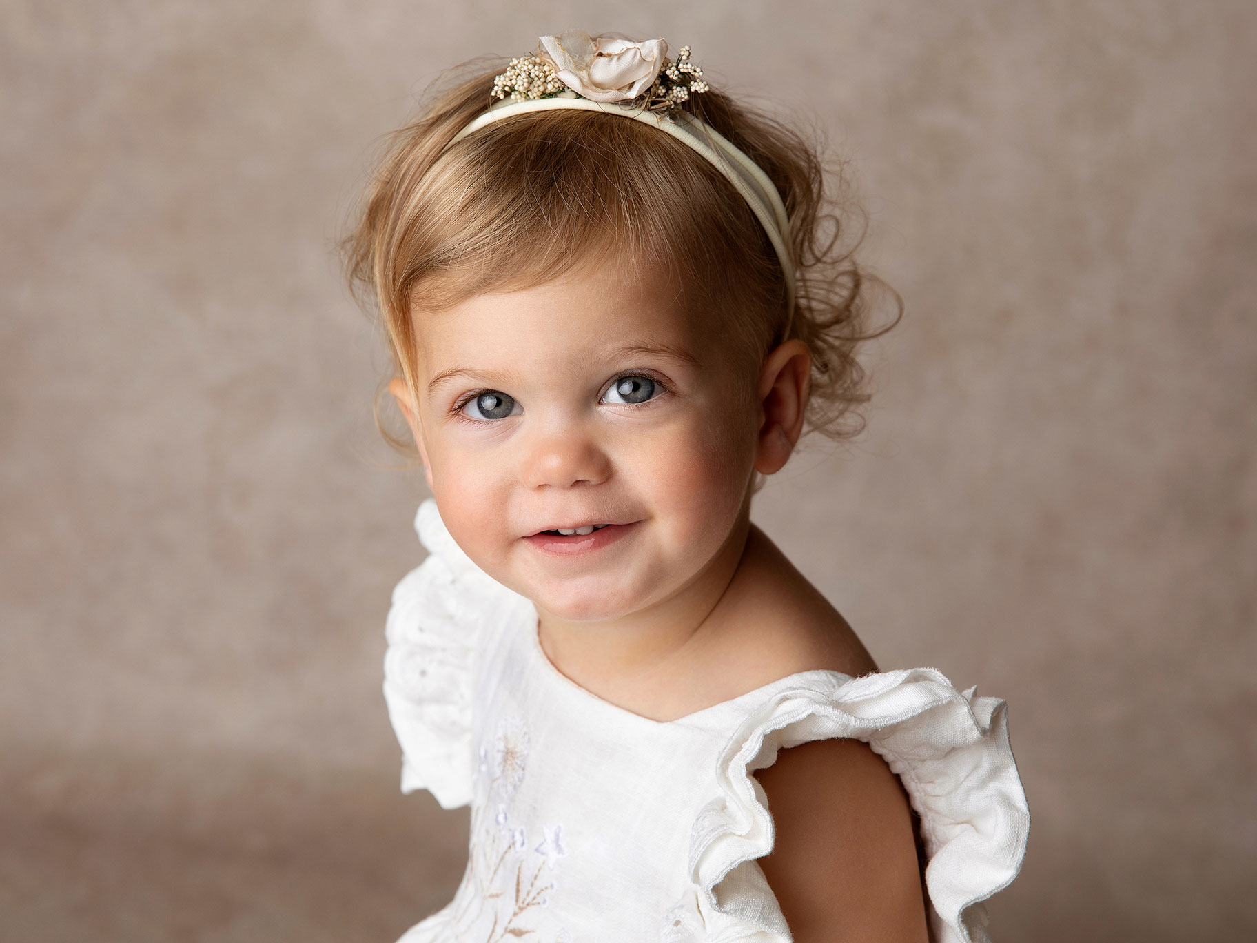 Liten babyflicka som har fin klänning på sig när hon blir fotograferad i studio i Malmö.