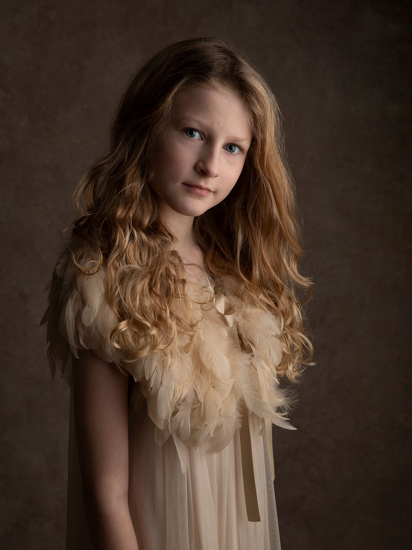 Flicka med lockar tittar in i kameran i en mer konstnärlig bild.