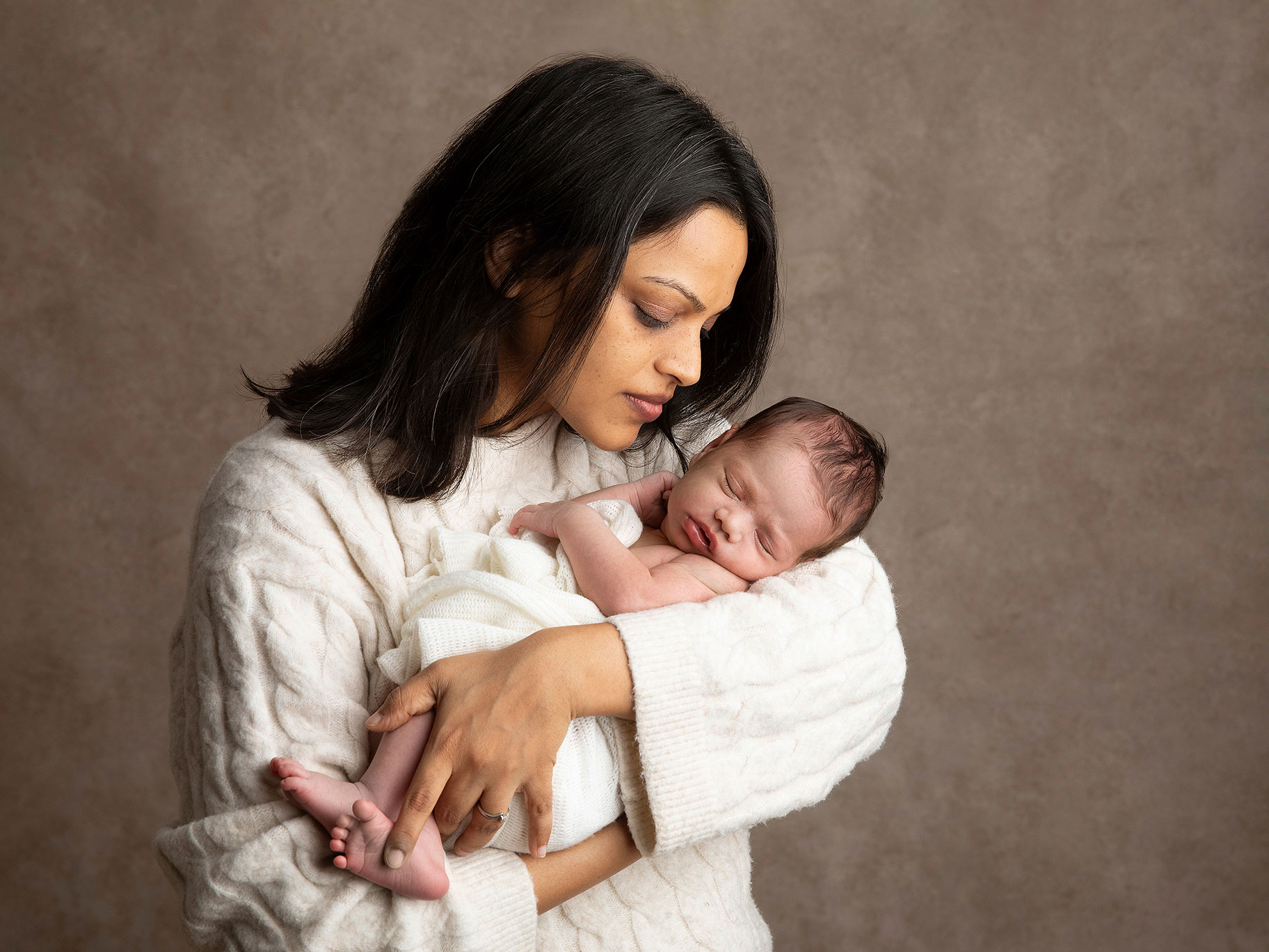 Nybliven mamma tittar på sin lilla baby.