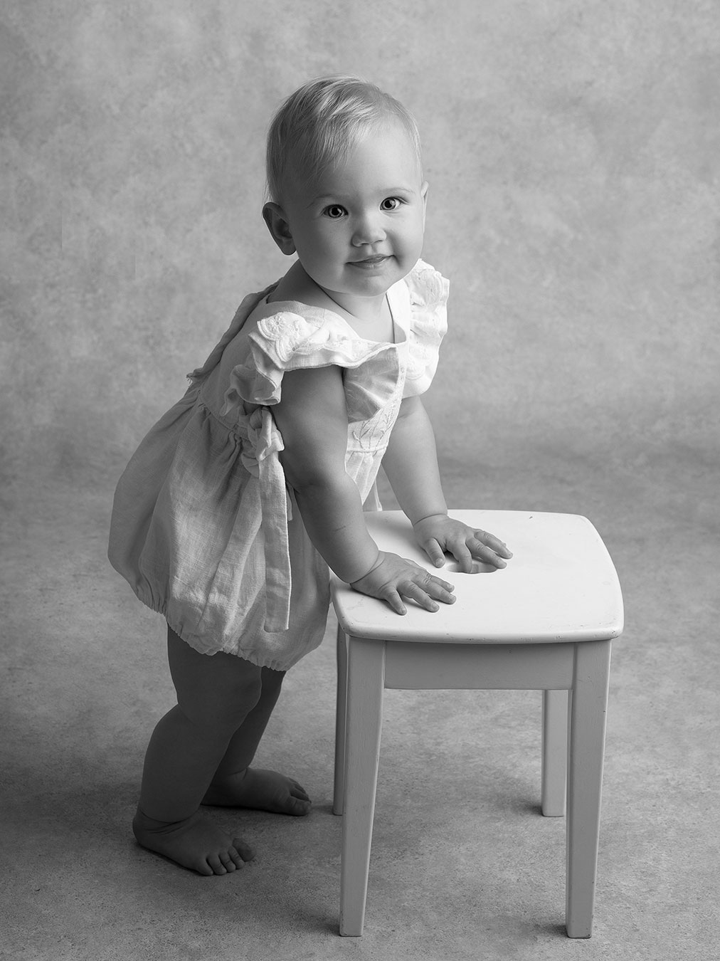 Baby flicka står fint under en fotografering hos Anna Arvidsson i Skåne.