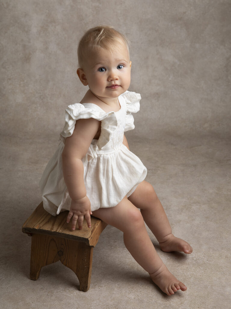 Liten baby som sitter fint under en barnfotografering i Skåne hos Anna Arvidsson i Malmö.