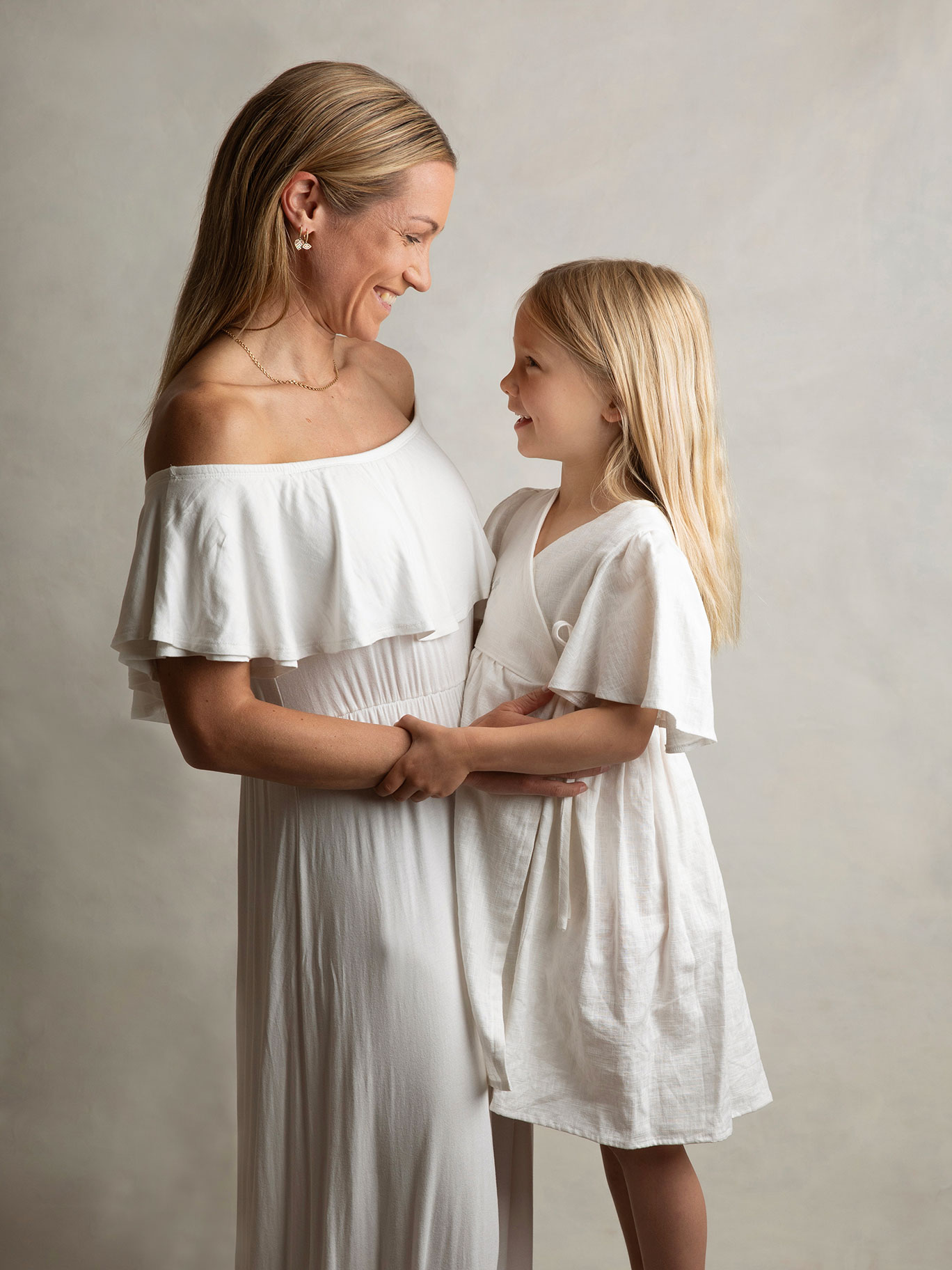 Vacker kontakt mellan fotografen och en mamma och sin dotter, fångat i en fotostudio i Malmö.