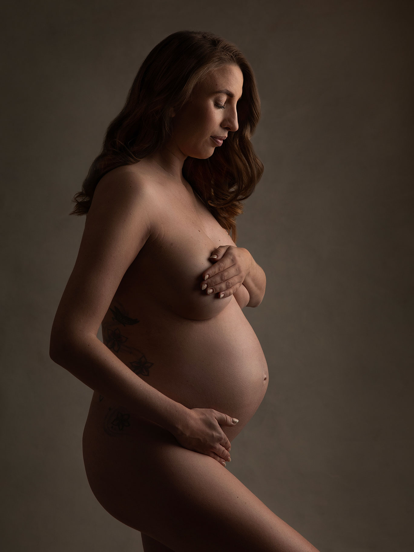 Vacker bild på gravid kvinna tagen i fint ljus i studio i Malmö.
